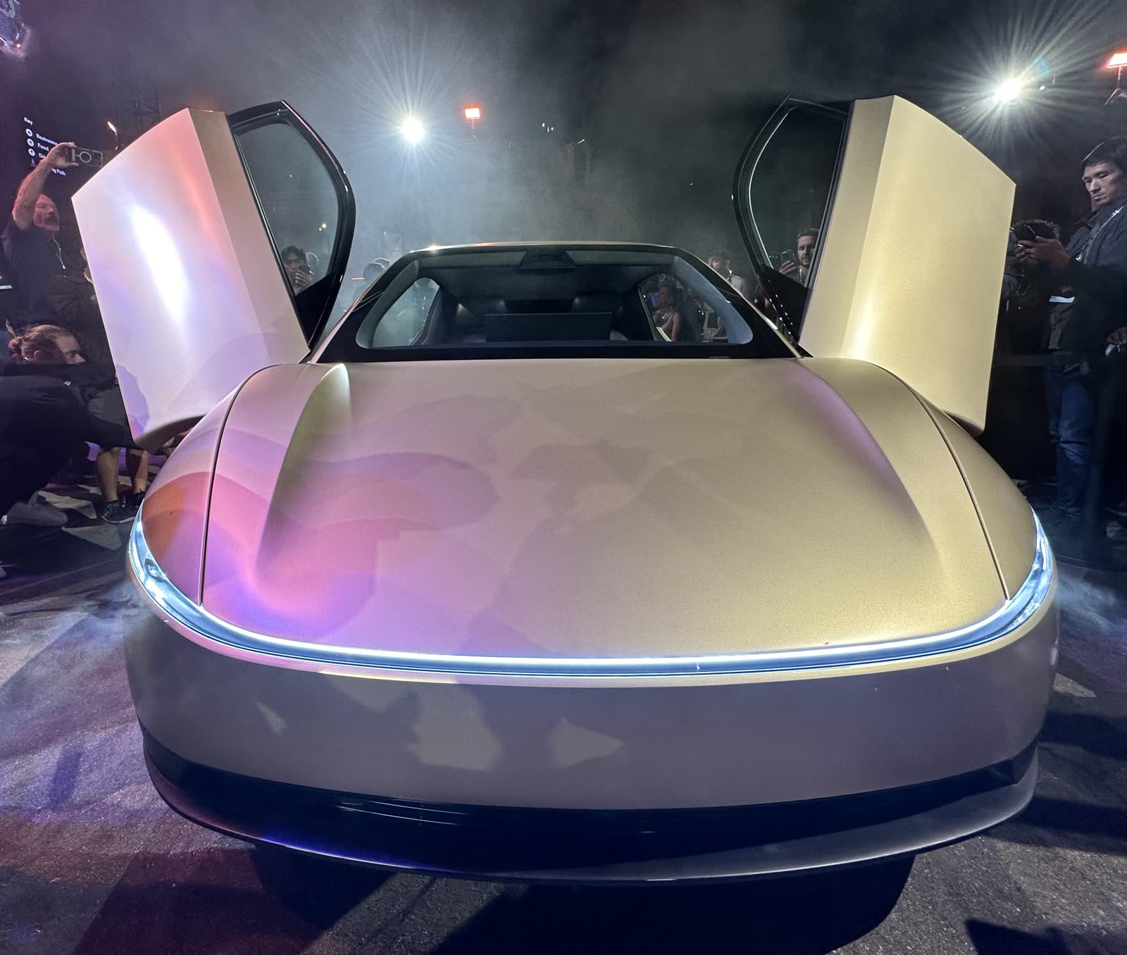 Front of a gold Cybercab with butterfly doors open